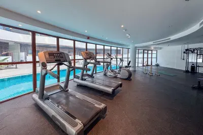 a gym with several treadmills and a swimming pool at Designer Loft Studio with top Amenities in JVC in Dubai