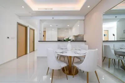 a dining room with a white table and white chairs at Ultra-Luxury Midtown 2 Bed Full Burj Khalifa Views in Dubai