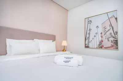 a white bedroom with a white bed with a sign on it at Ultra-Luxury Midtown 2 Bed Full Burj Khalifa Views in Dubai