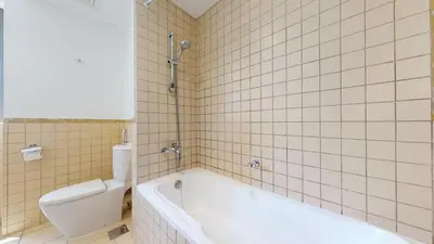 a bathroom with a white tub and a toilet at Vacationer I Royale 3 Bedroom I Steps to JBR Beach I Jumeirah I Free Gym, Pool, Parking & Wi-Fi in Dubai