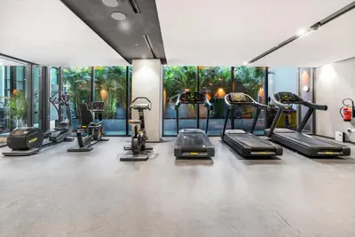 a gym with several treadmills and elliptical machines at Stylish Studio in The Autograph in Dubai