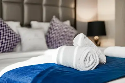 a rolled up white towel on a bed at Studio with a Large Terrace at DAMAC Majestine in Dubai