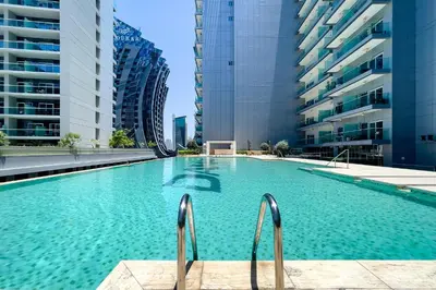 a swimming pool in a city with tall buildings at Studio with a Large Terrace at DAMAC Majestine in Dubai