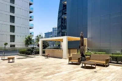 a pavilion with chairs and tables in front of a building at Studio with a Large Terrace at DAMAC Majestine in Dubai