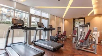 a gym with treadmills and ellipticals in a room at Studio with a Large Terrace at DAMAC Majestine in Dubai