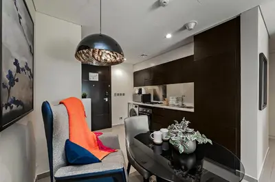 a kitchen and dining room with a table and chairs at Studio with a Large Terrace at DAMAC Majestine in Dubai