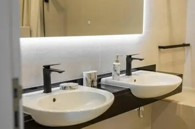 a bathroom with two white sinks and a mirror at Luxury 2 BHK in Dubai Marina By dPie DEC 1907 in Dubai