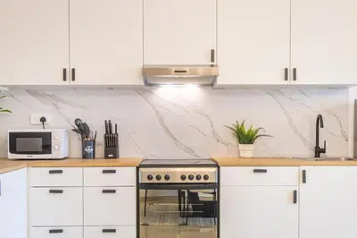 a kitchen with white cabinets and a stove at Luxury 3BHK in Dubai Marina DEC 1307 in Dubai