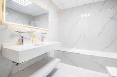 a white bathroom with a sink and a mirror at Luxury 2 BHK with Floating Bed in Dubai Marina DEC 1803 in Dubai
