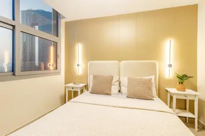 a bedroom with a large white bed with two windows at Lux 3BHK in Dubai Marina w Marina View DEC 1407 in Dubai