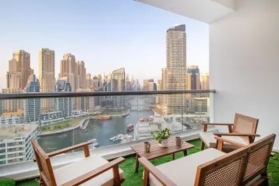 a balcony with tables and chairs and a view of a city at Lux 3BHK in Dubai Marina w Marina View DEC 1407 in Dubai