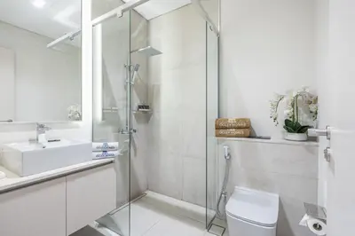 a bathroom with a shower and a toilet and a sink at Lovely Duplex Townhouse minutes from Downtown in Dubai