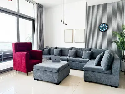 a living room with a blue couch and a red chair at Luxury 3BHK in Dubai Marina DEC 1603 in Dubai