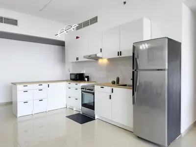 a kitchen with white cabinets and a stainless steel refrigerator at Luxury 3BHK in Dubai Marina DEC 1603 in Dubai