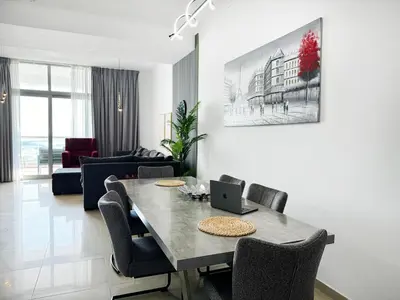 a living room with a table with chairs and a laptop at Luxury 3BHK in Dubai Marina DEC 1603 in Dubai