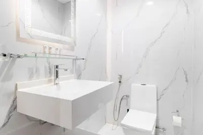 a white bathroom with a sink and a toilet at Lux 3BHK in Dubai Marina with Marina View DEC 1306 in Dubai