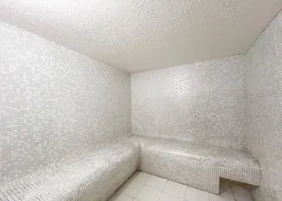 a bathroom with white tiled walls and a bench at Luxury 4 BHK in Dubai Marina DEC 2102 in Dubai