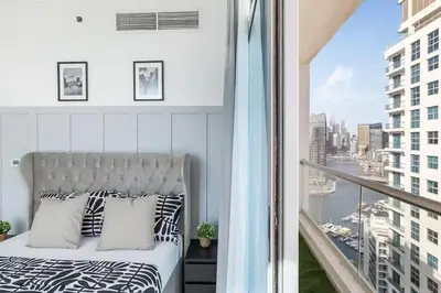 a bedroom with a bed and a balcony with a view at Luxury 4 BHK in Dubai Marina DEC 2102 in Dubai