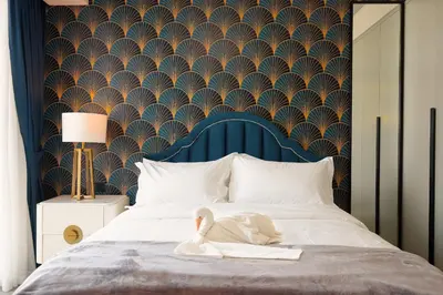 a swan is sitting on a bed with a wallpaper at KeyRock Living - Golf Gate Apt with Pool Access in Dubai
