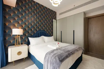 a bedroom with a large bed with a blue headboard at KeyRock Living - Golf Gate Apt with Pool Access in Dubai