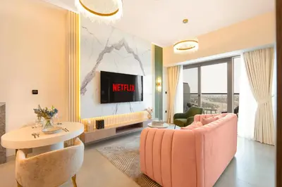 a living room with a pink couch and a tv at KeyRock Living - Golf Gate Apt with Pool Access in Dubai
