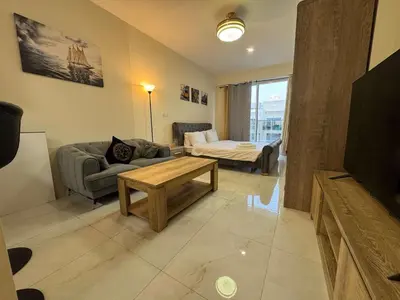 a living room with a couch and a table at Furnished Studio in JVC Hassle-Free Living in Dubai