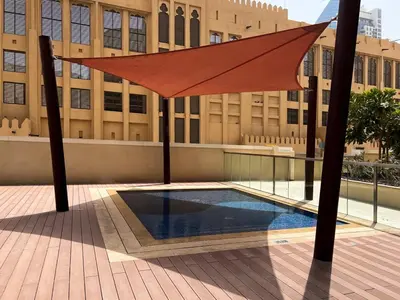 a large orange umbrella over a pool in front of a building at Vogue Downtown Bellevue Towers near Burj Khalifa and Dubai Mall, One Bedroom Apartment with City View, Full Access to all Amenities in Dubai
