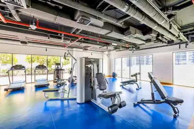 a gym with several treadmills and a blue floor at Vogue Downtown Bellevue Towers near Burj Khalifa and Dubai Mall, One Bedroom Apartment with City View, Full Access to all Amenities in Dubai