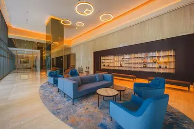 a lobby with blue couches and tables in a building at Vogue Downtown Bellevue Towers near Burj Khalifa and Dubai Mall, One Bedroom Apartment with City View, Full Access to all Amenities in Dubai