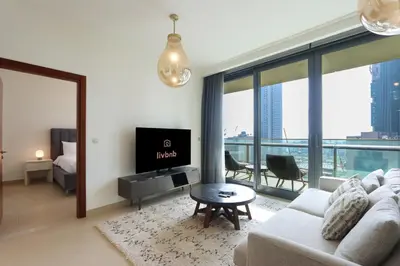 a living room with a couch and a tv and a table at Prime Located 2BR Near Burj Khalifa & Dubai Mall in Dubai