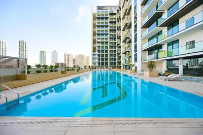a large blue swimming pool in a building at Golden Stays - Binghatti Amber I Luxury 1BR Apartment I Fully Furnished I Pool & Gym in Dubai
