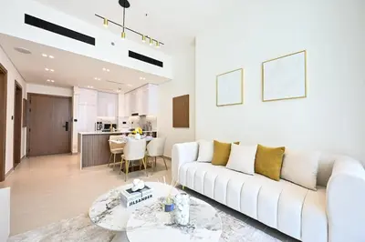 a living room with a white couch and a table at Golden Stays - Binghatti Amber I Modern 1BR Apartment I Balcony, Pool & Gym Access in Dubai