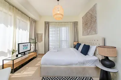 a bedroom with a white bed and a large window at Lovely 1BR Apartment Bahar 6 JBR in Dubai
