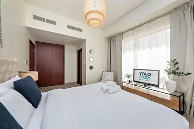 a bedroom with a large white bed and a window at Lovely 1BR Apartment Bahar 6 JBR in Dubai