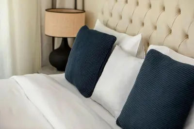 two blue pillows are sitting on a white bed at Lovely 1BR Apartment Bahar 6 JBR in Dubai