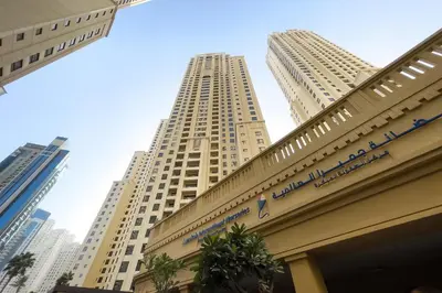 a building with two tall buildings in the background at Lovely 1BR Apartment Bahar 6 JBR in Dubai