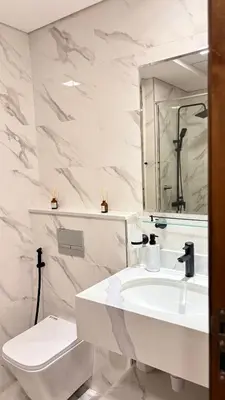 a white bathroom with a sink and a toilet at Best Sunrise Holiday Home in Dubai