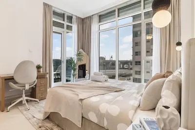 a bedroom with a bed and a desk and a window at Lux 3BHK in Marina with Pool Table Opal 305 in Dubai