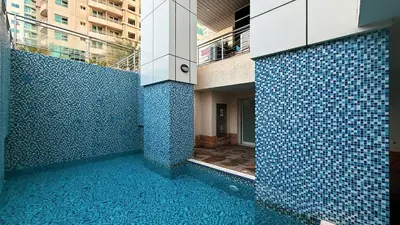 a building with blue tiled walls and a swimming pool at Lux 3BHK in Marina with Pool Table Opal 305 in Dubai
