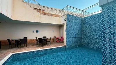 a house with a swimming pool with a table and chairs at Lux 3BHK in Marina with Pool Table Opal 305 in Dubai