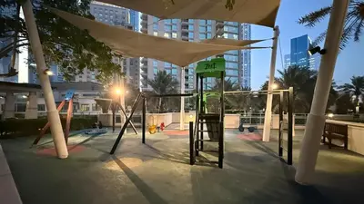 a playground in a city with a swing set at Lux 2BHK w Marina view w Sky Light Mesk 2007 in Dubai