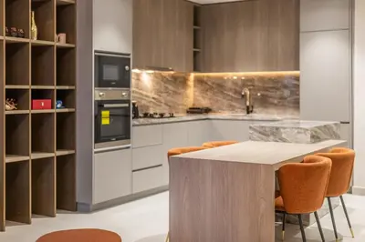 a kitchen with a wooden table and orange chairs at Luxury 1 BHK in Dubai Marina JVC 904 in Dubai