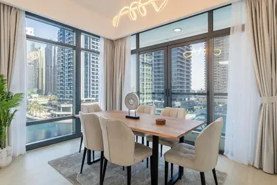 a dining room with a table and chairs and large windows at Luxury 2BHK Stunning Skyline Lakeview in JLT 401 in Dubai