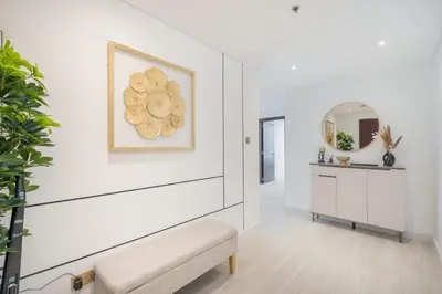 a white hallway with a bench and a mirror at Luxury 2BHK in Jumeirah Late Towers JLT 2609 in Dubai