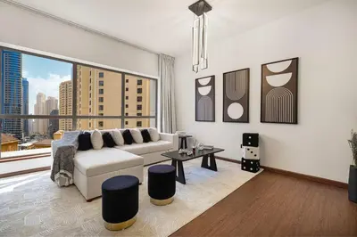 a living room with a couch and a large window at Lux 4BHK in JBR 5 Mins Walk to Beach Sadaf 8 102 in Dubai