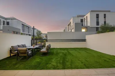a patio with a table and chairs on a lawn at Luxury Villa in Jebel Ali Village By dPie in Dubai