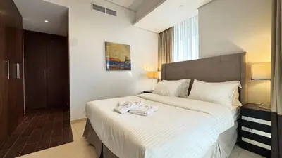 a bedroom with a bed with two towels on it at Luxury 1BHK located in The Matrix 1-2707 in Dubai