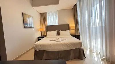 a hotel room with a bed with a robe on it at Luxury 1BHK located in The Matrix 1-2707 in Dubai