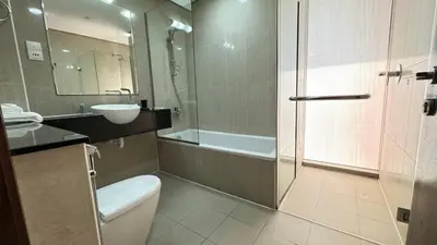 a bathroom with a toilet and a sink and a shower at Luxury 1BHK located in The Matrix 1-2707 in Dubai