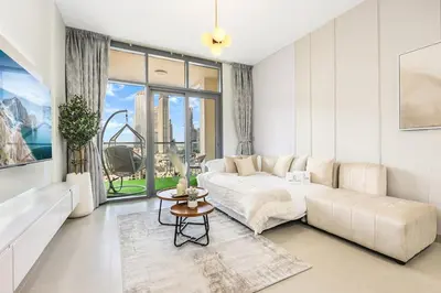 a white living room with a couch and a table at FIRST CLASS 2BR Downtown Glam Burj View in Dubai